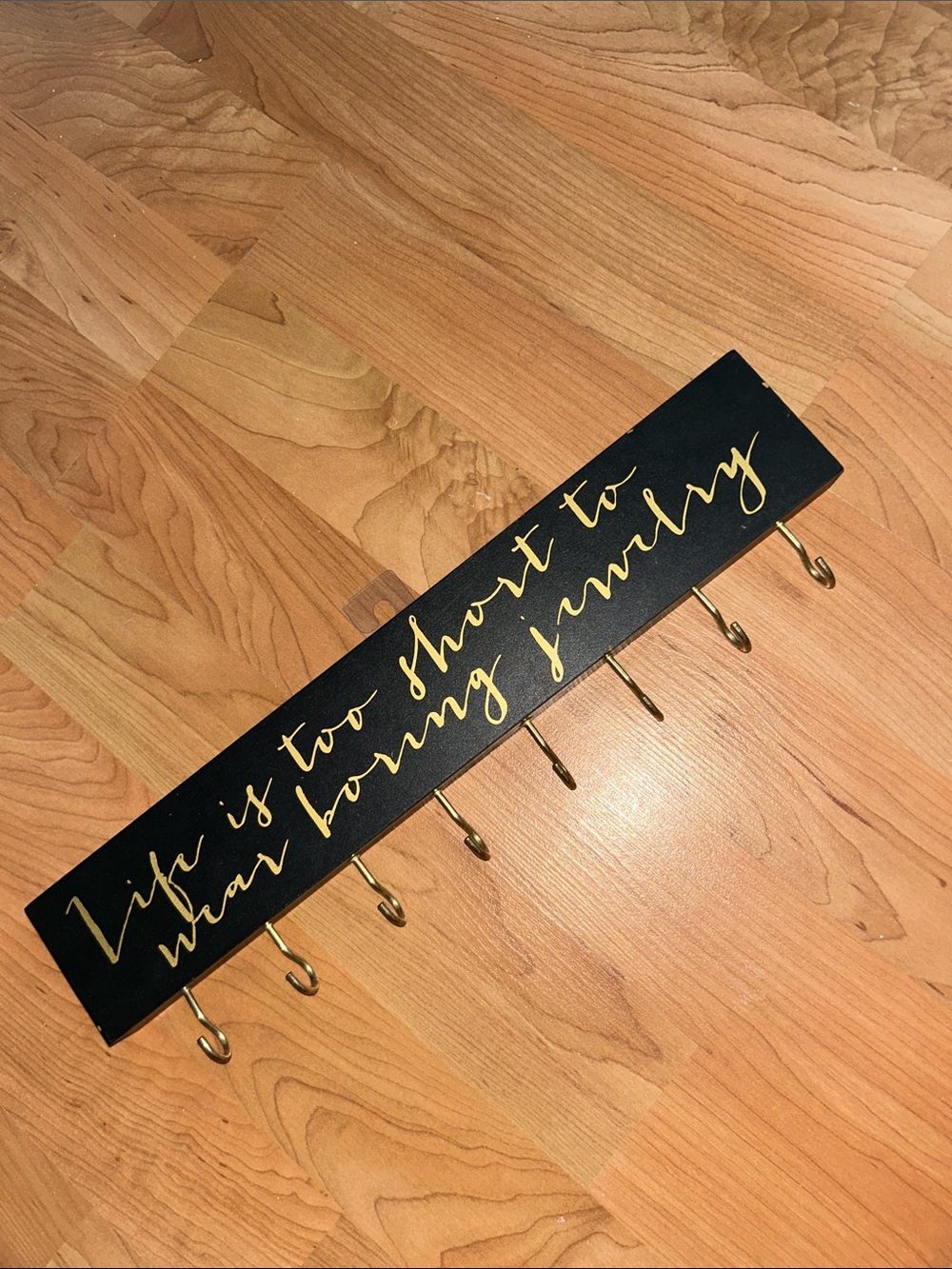 Black Wall Hook Rack with Gold Script Lettering